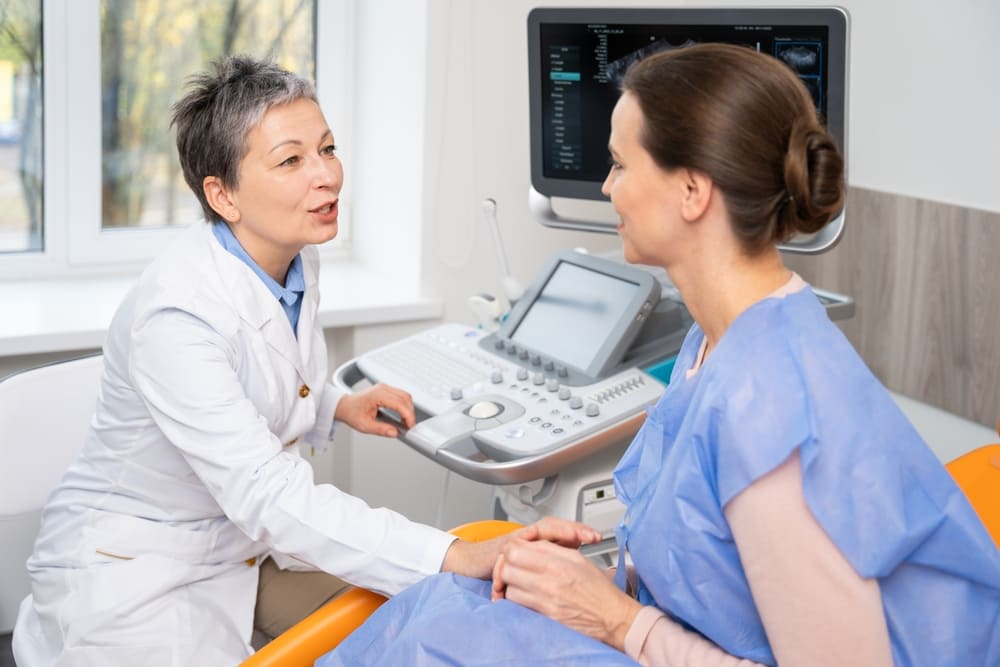 Female doctor talking to patient during a consultation, emphasizing importance of health history and screening questions.
