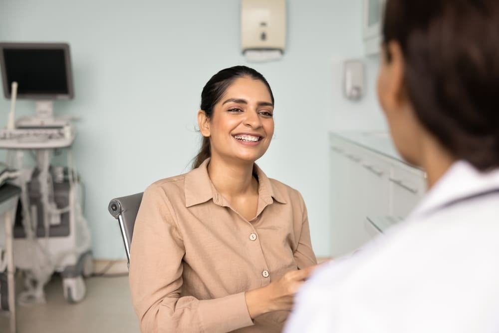 Smiling patient speaking with healthcare provider during consultation about pre-test instructions in a medical clinic